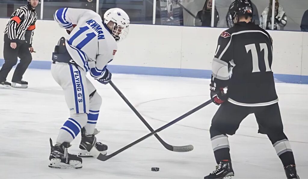 Clayton Newman skates with the puck in a Michigan high school hockey game for Gladwin hockey.