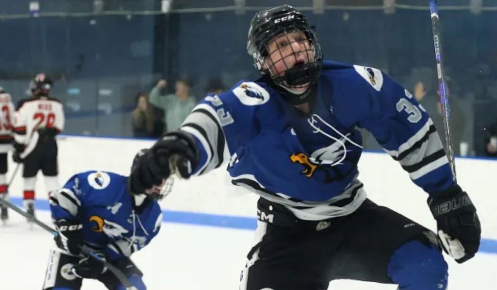 Bode Farr celebrates after scoring a goal for Utica Eisenhower hockey.